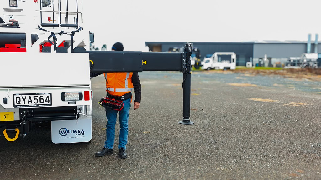 A lines crane truck fully extending its crane while short jacked.