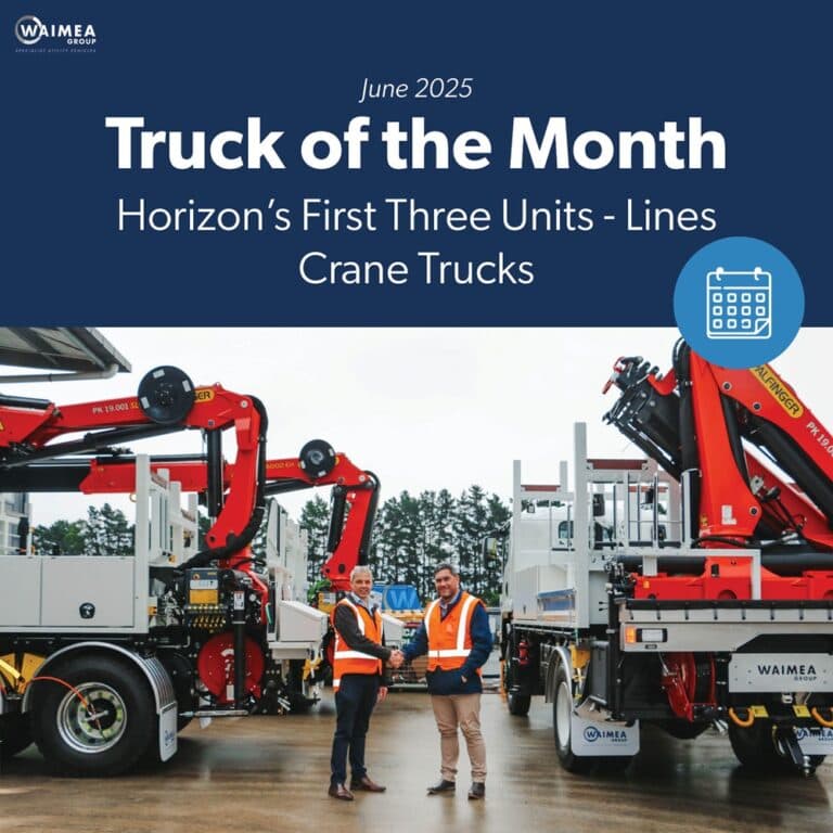 A salesman and a customer shaking hands standing in front of three lines crane trucks that are being handed over