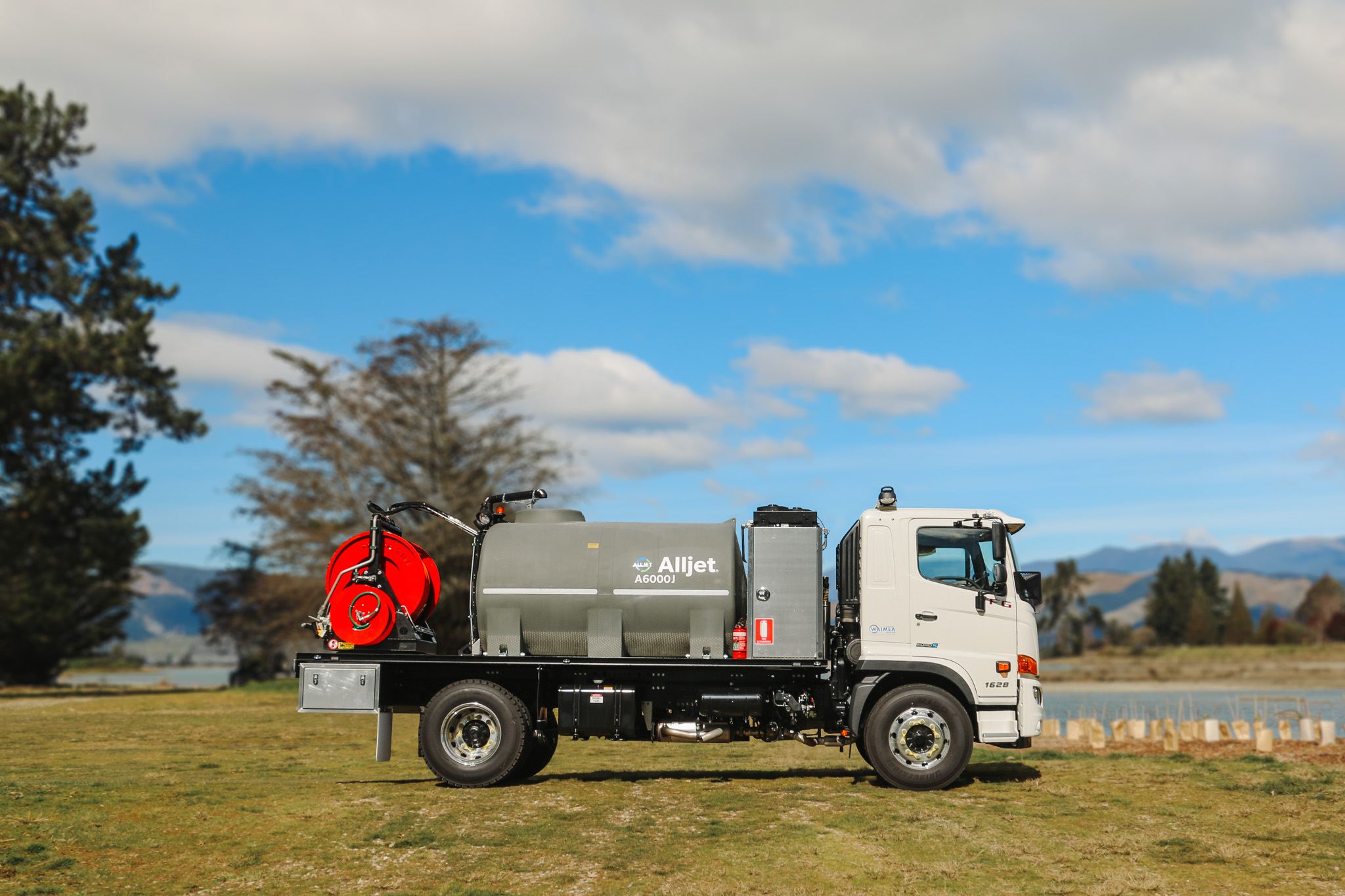 The Allvac® A6000J Jetter (4) A large jetting specialist utility truck with a large grey tank and two big hose reels of different sizes on the back, with toolboxes and other convenient features fitted.