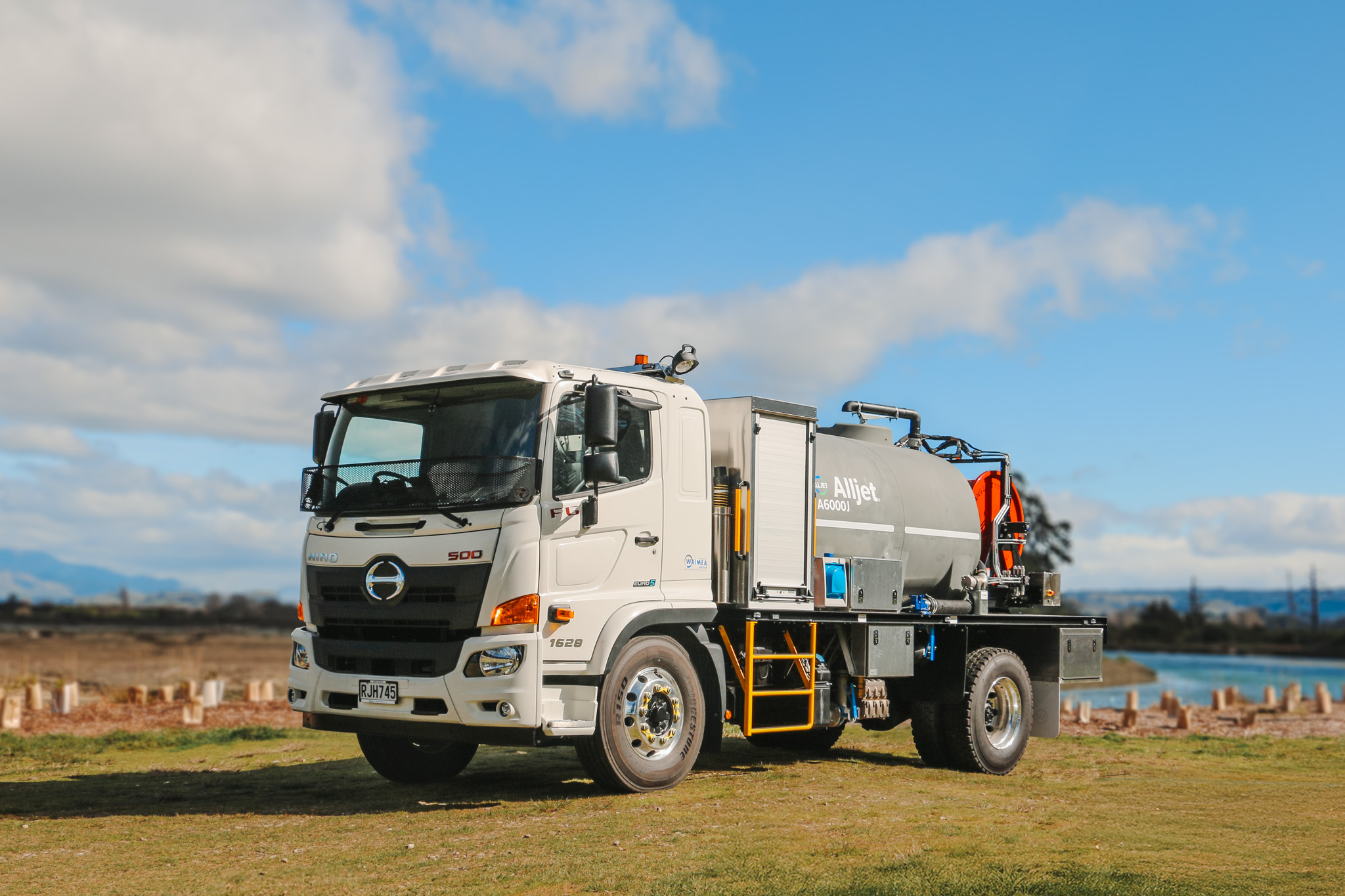 The Allvac® A6000J Jetter (5) A large jetting specialist utility truck with a large grey tank and two big hose reels of different sizes on the back, with toolboxes and other convenient features fitted.