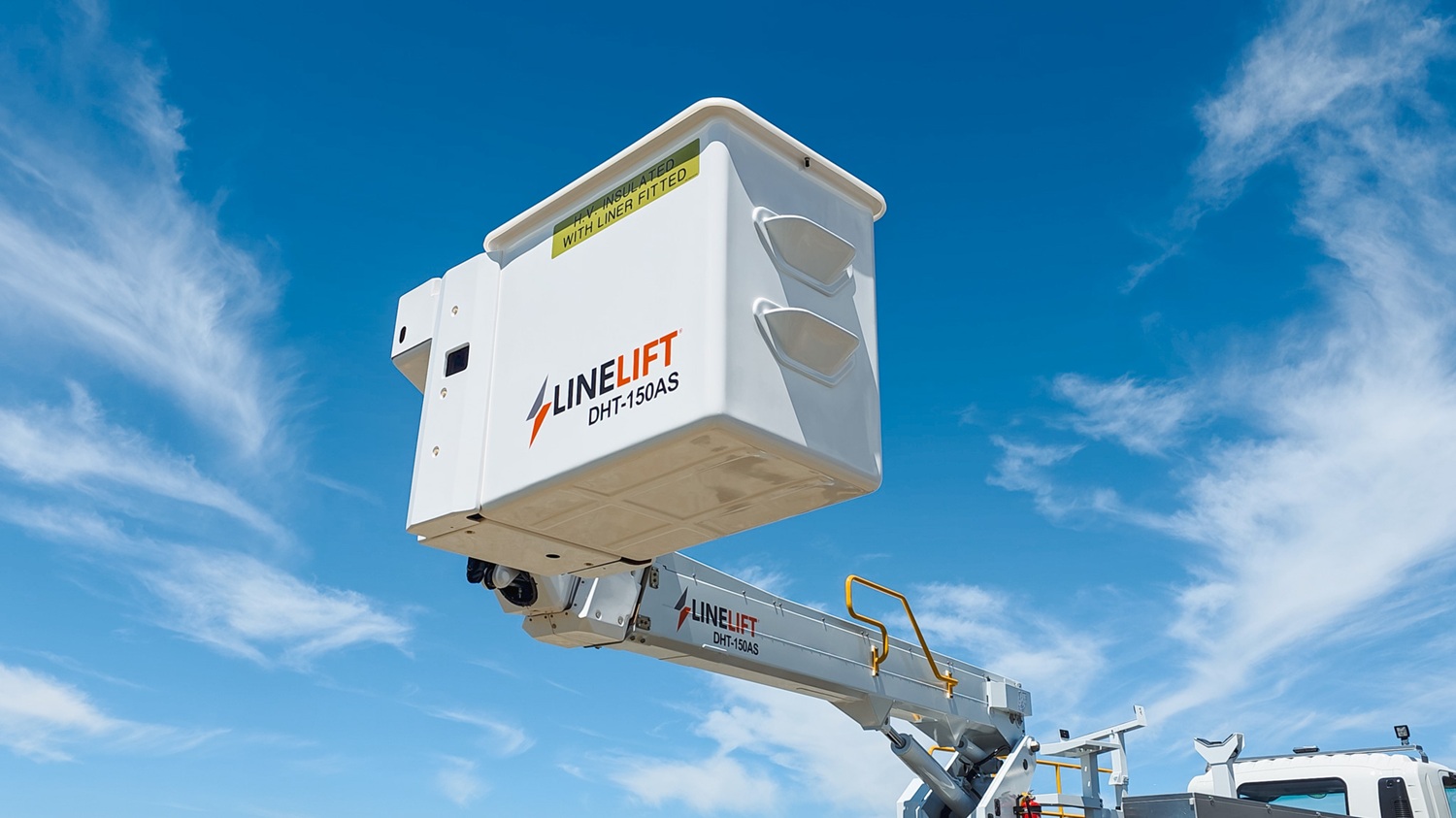 A vacuum tanker truck painted pale blue, with a large tank, side trays, and a compact chassis, parked in a green vineyard