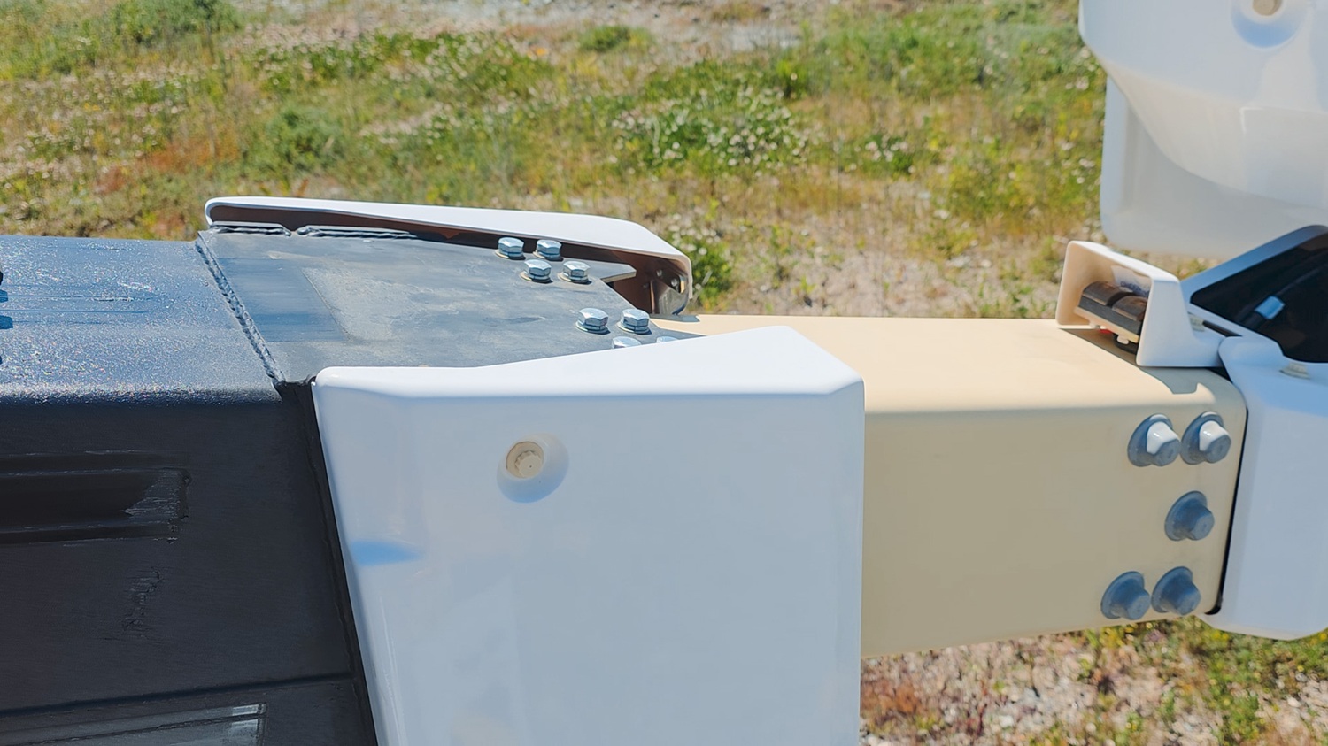 A vacuum tanker truck painted pale blue, with a large tank, side trays, and a compact chassis, parked in a green vineyard