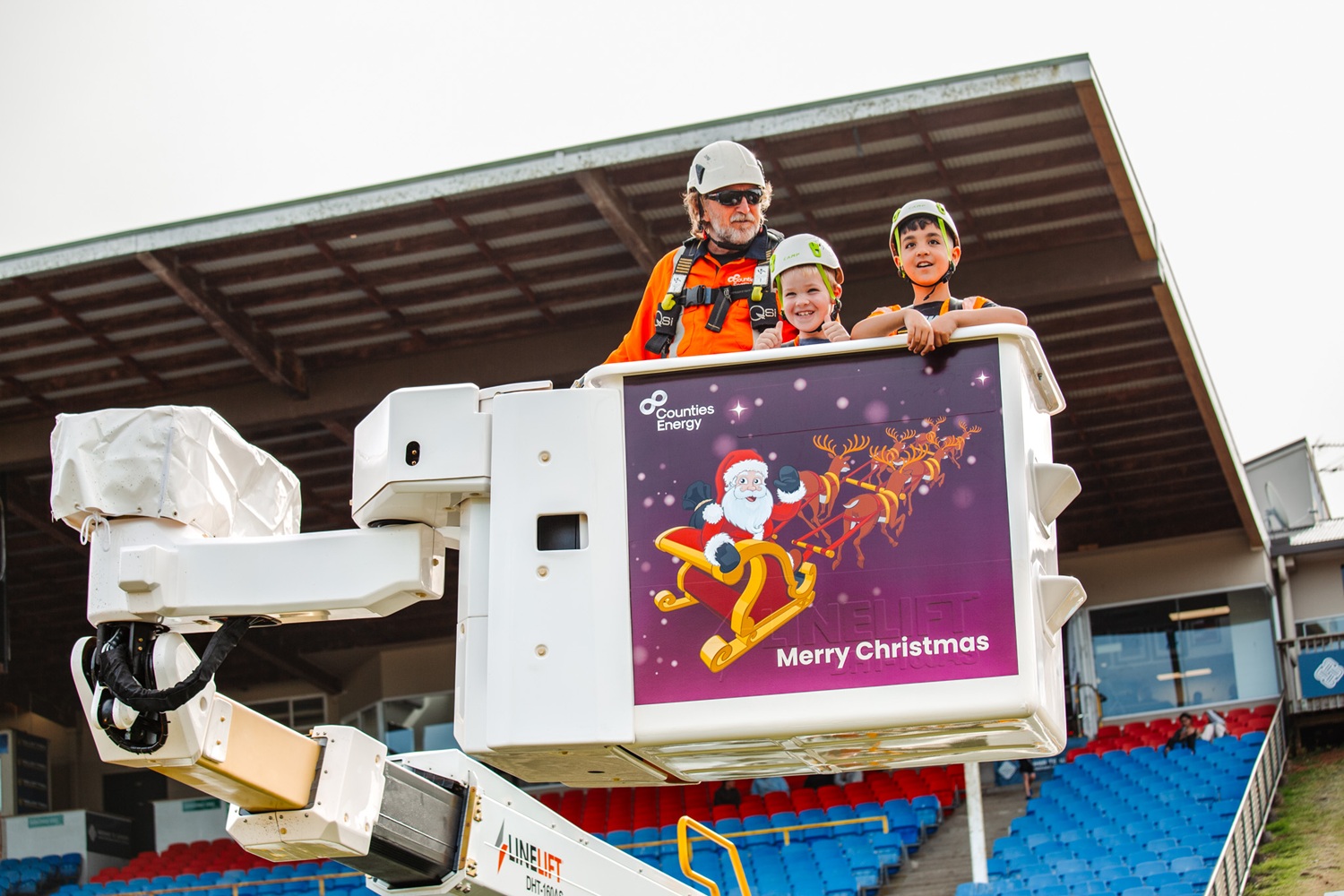 A bucket truck EWP giving rides to children advertising Counties Energy.