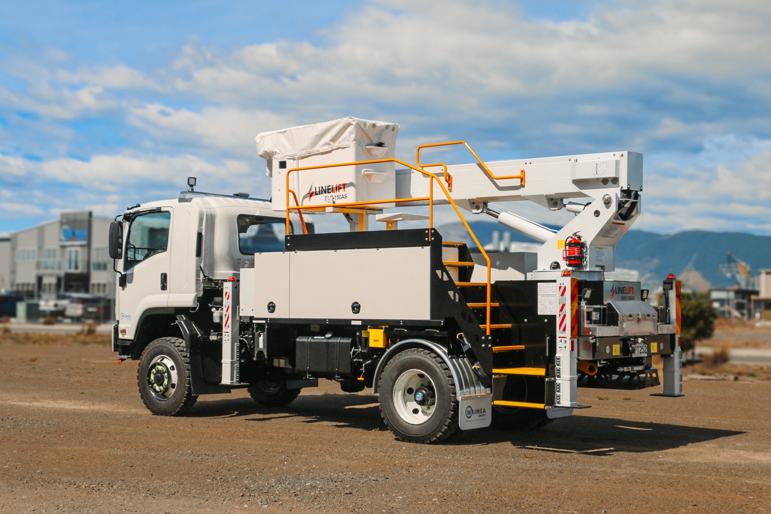 A white EWP truck with Linelift® branding set up in an open area, with the boom and bucket up and extending diagonally to the left.