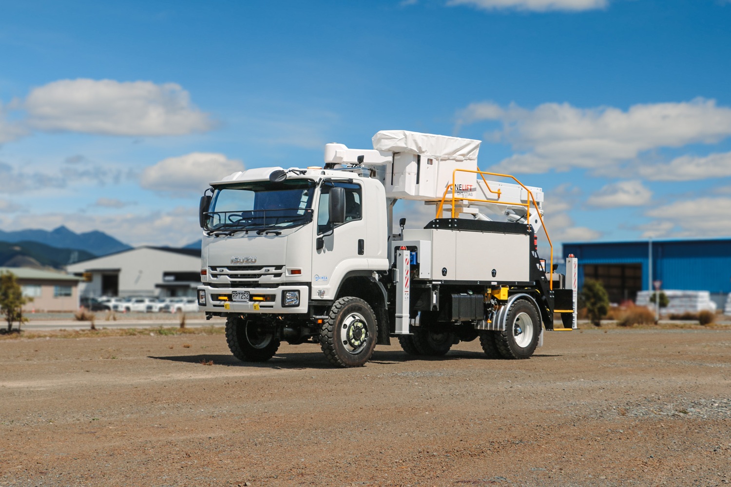 A white EWP truck with Linelift® branding set up in an open area, with the boom and bucket up and extending diagonally to the left.