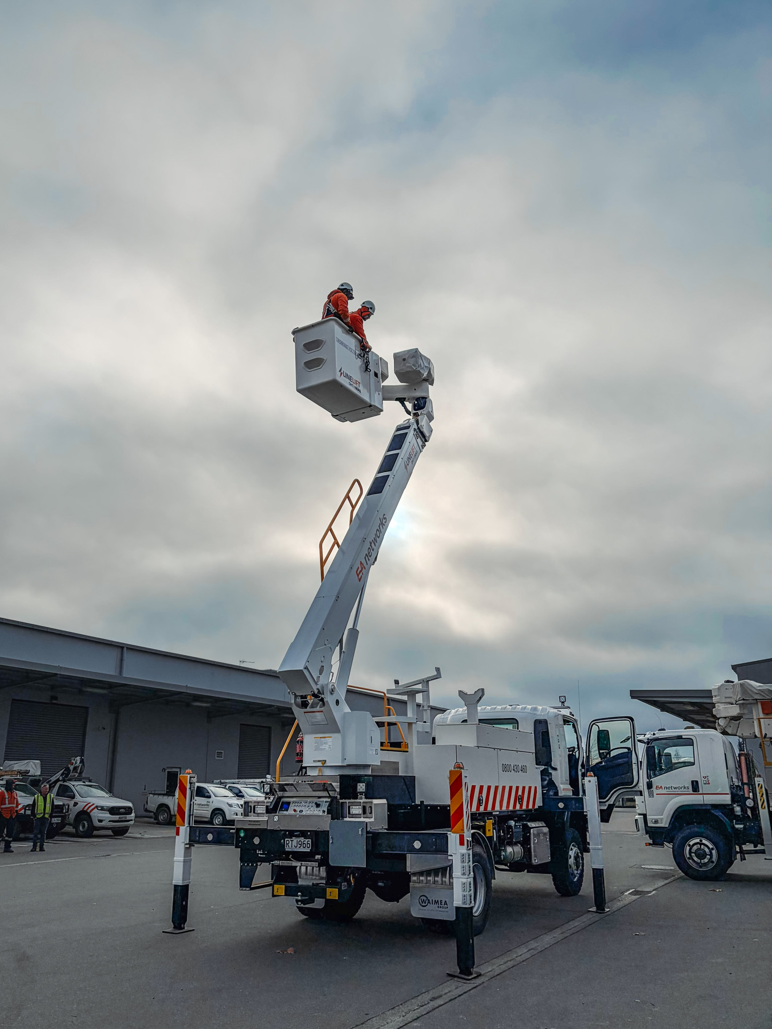 A white specialist elevated work platform truck parked on gravel, with a boom and bucket mounted on top with Linelift® branding and large toolboxes on the sides.