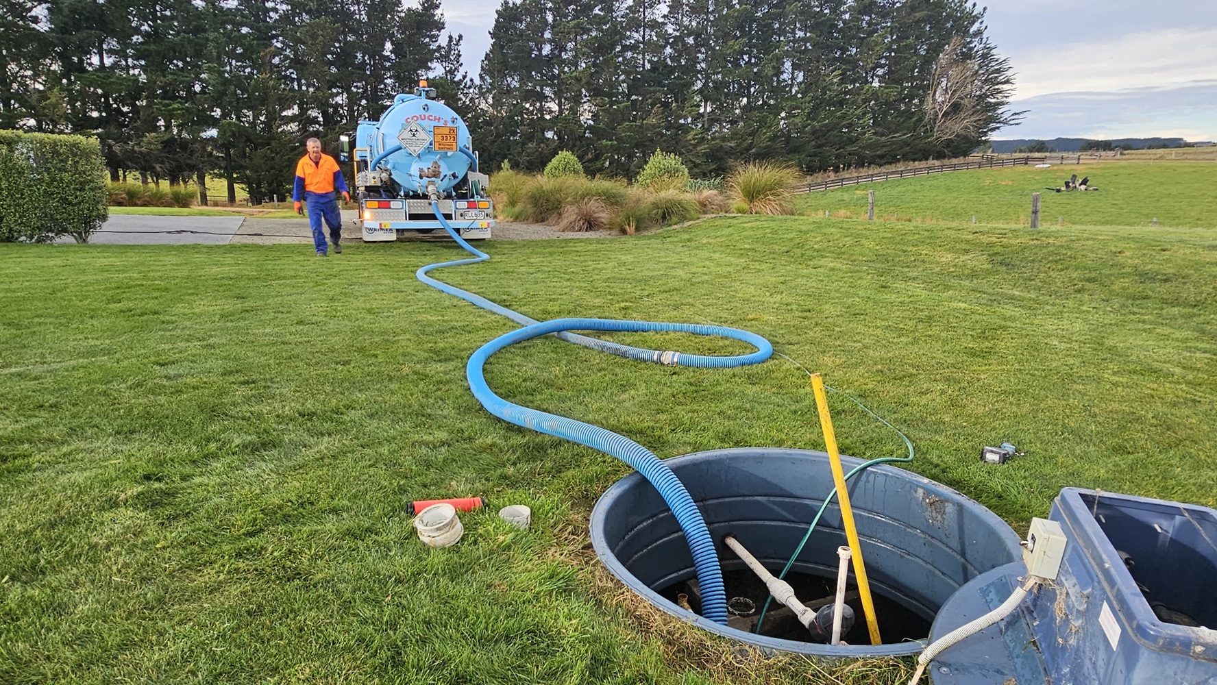 An Allvac® hydro excavator parked on a construction site with a blue hose extending from it several metres to the excavation site.